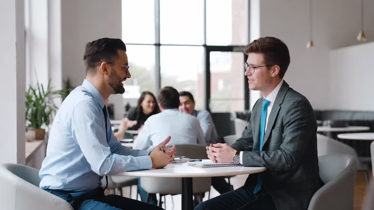 Two professionals having a deeper one-on-one discussion away from the crowd