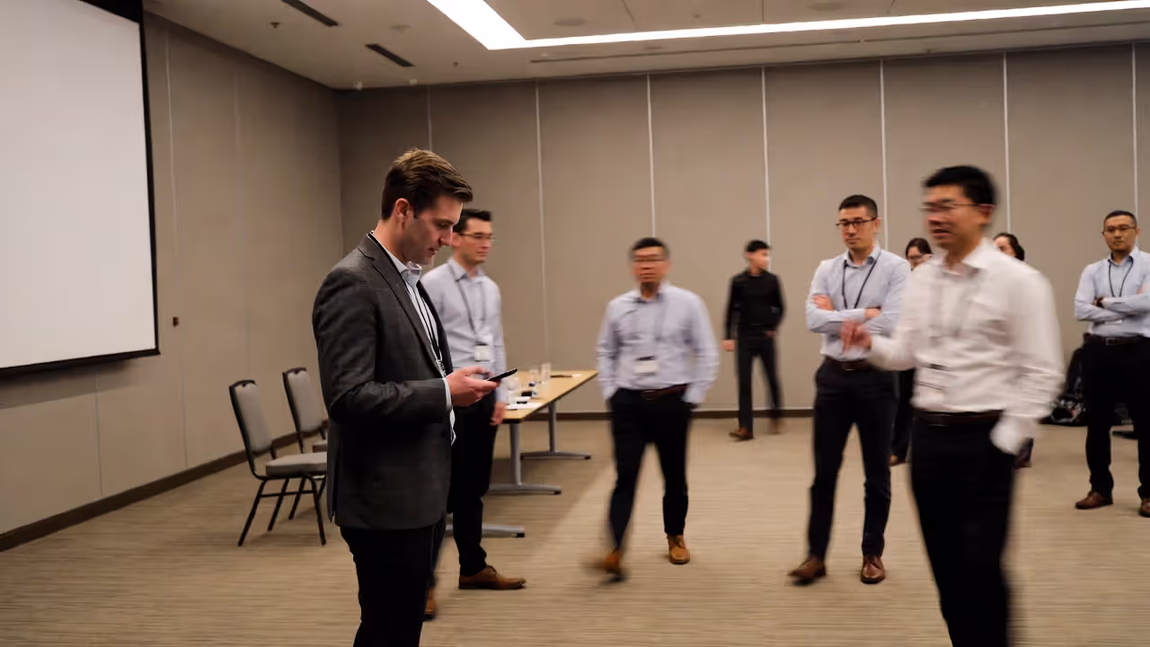 Attendee approaching a speaker standing alone after a conference talk