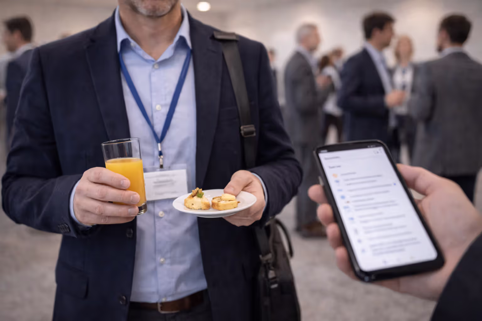 Attendee juggling a drink, small plate, and a blurred name badge in a conference hall